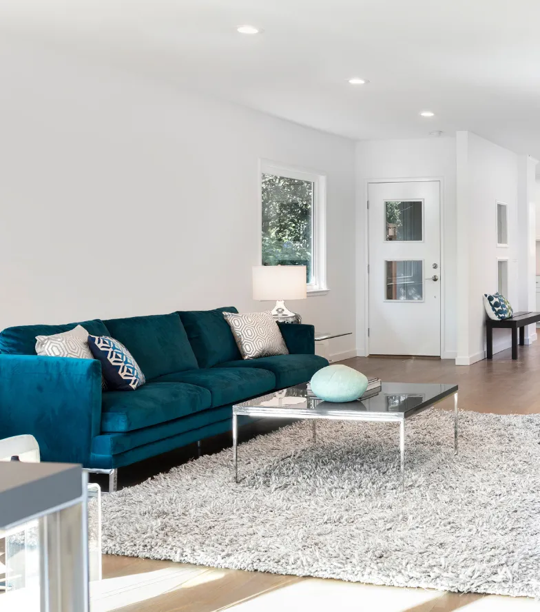 Finished Los Angeles living room remodel with bright white walls, updated flooring, modern furniture, and open interior layout.