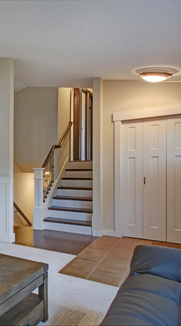 Remodeled Los Angeles home interior with staircase, closet doors, tile flooring, and updated living room layout.