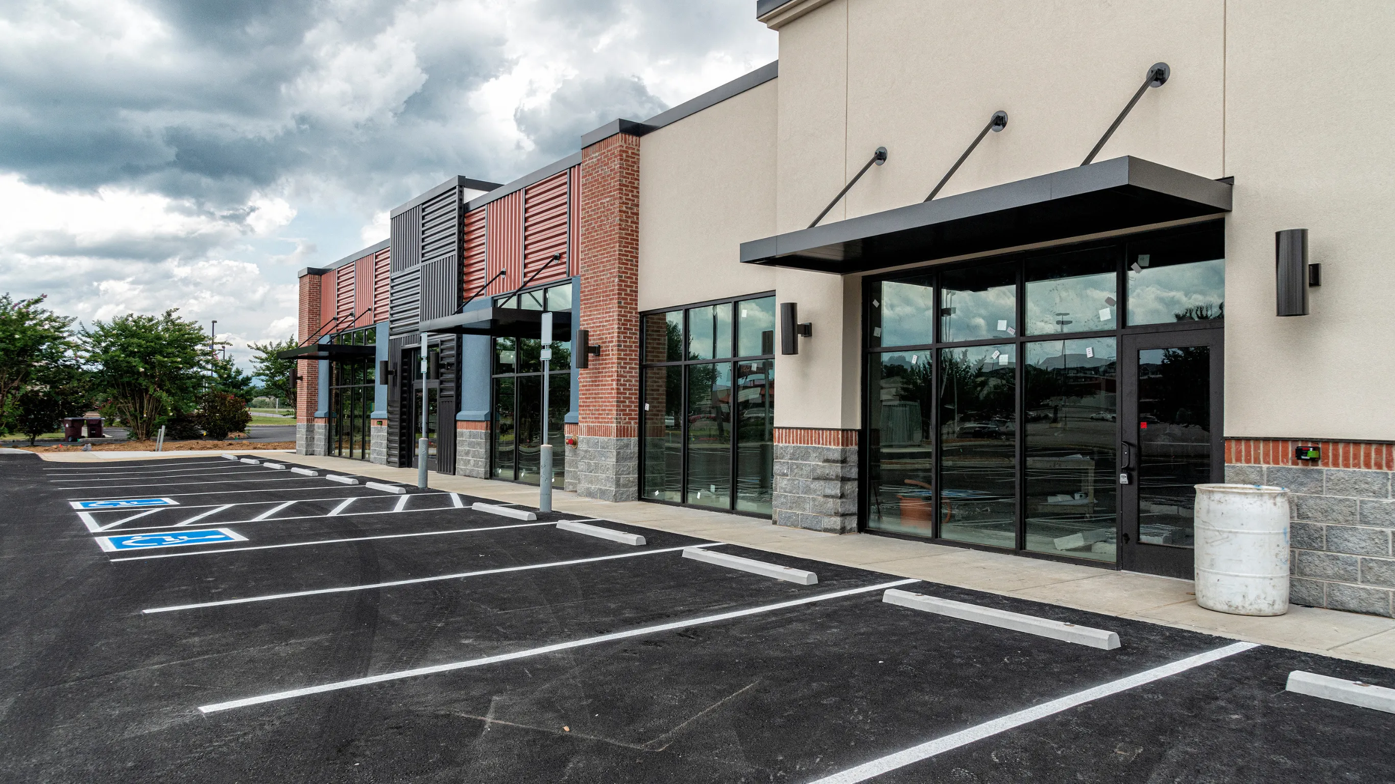 After commercial remodeling project in Los Angeles featuring a modern storefront exterior, glass entry, updated facade, parking area, and improved business curb appeal.
