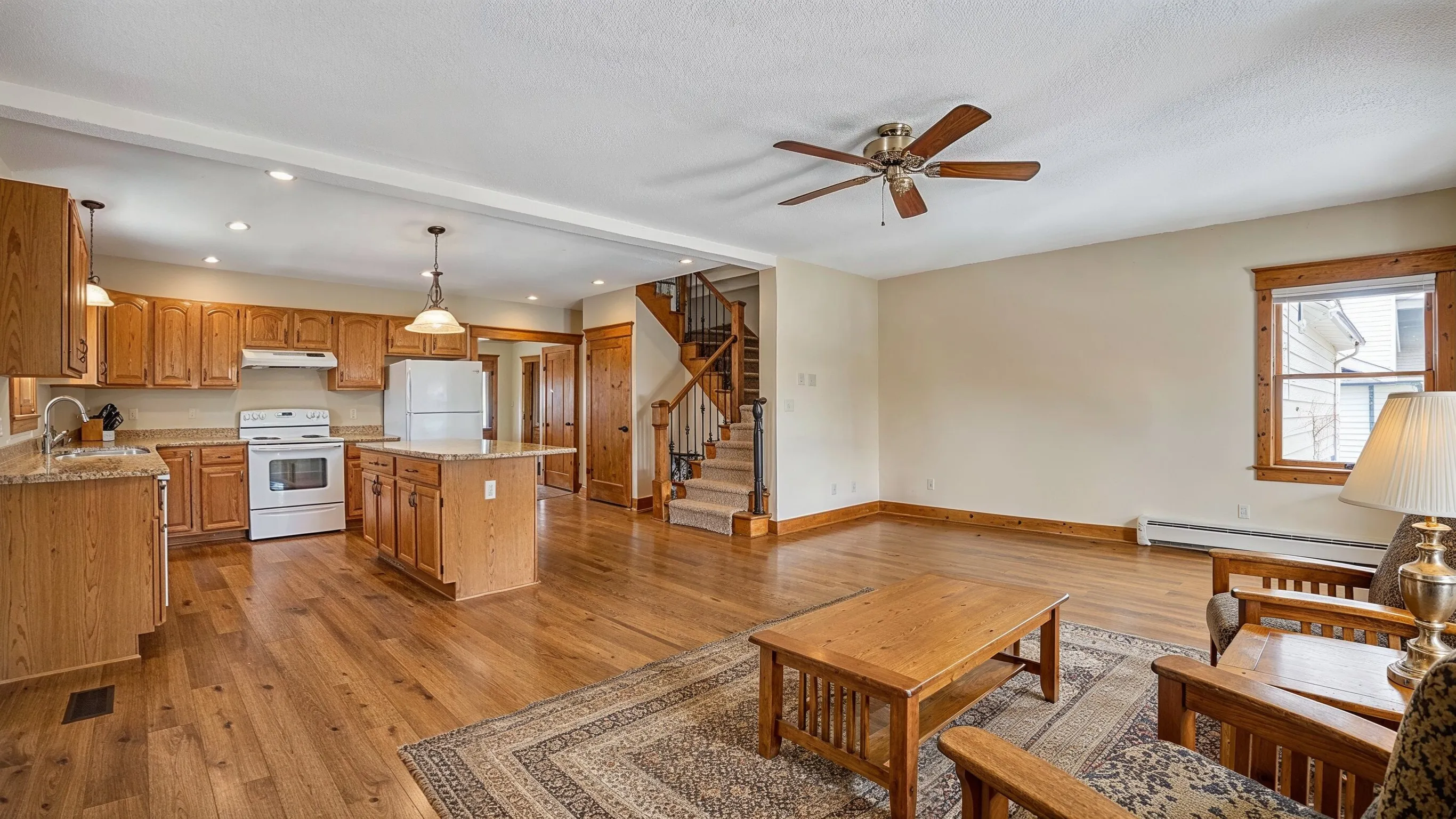 Before whole home remodeling project in Los Angeles showing an older open living and kitchen area with wood finishes, dated layout, and renovation potential.