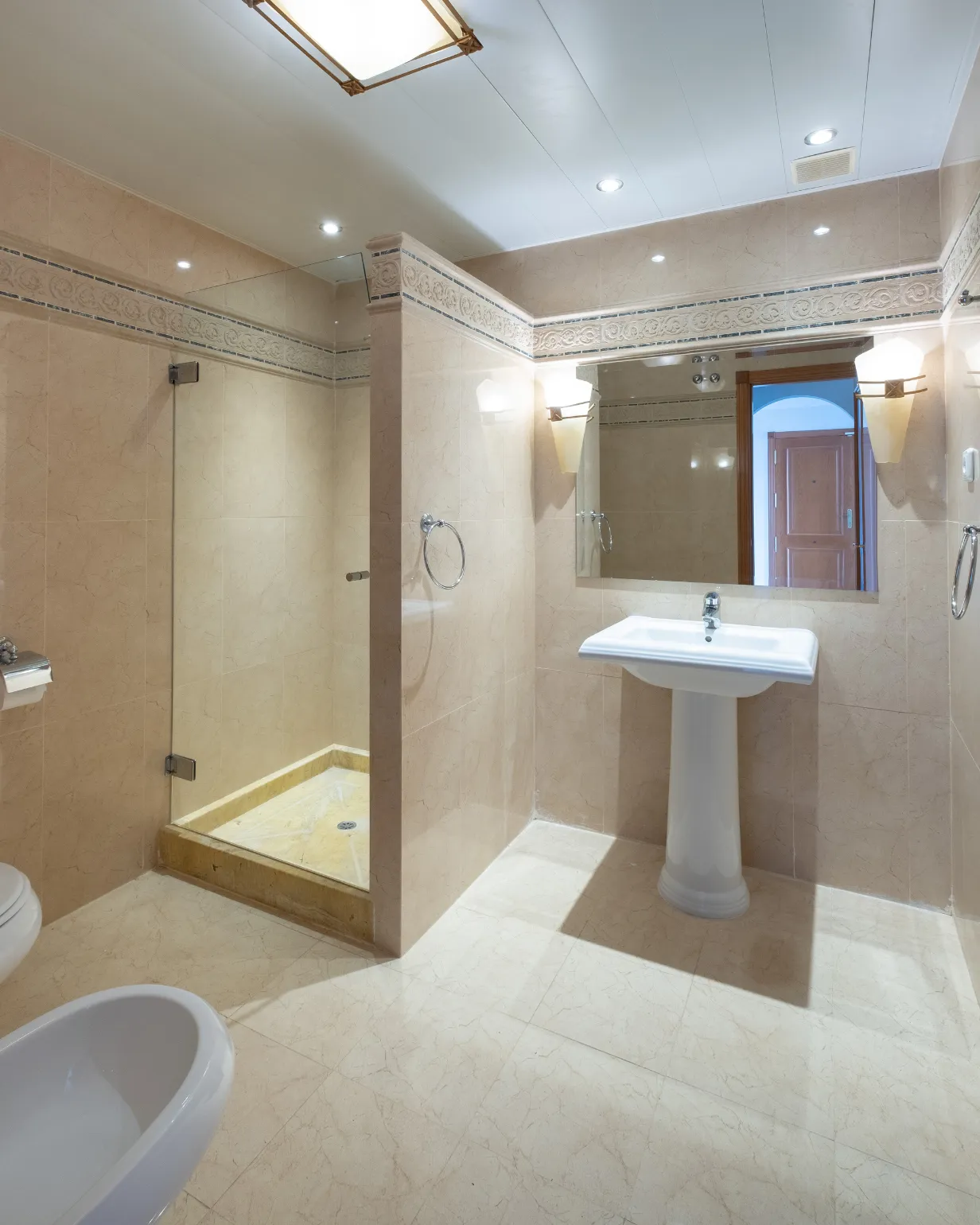 Bathroom remodeling in Los Angeles with glass shower, tile walls, pedestal sink, updated lighting, and bathroom renovation planning