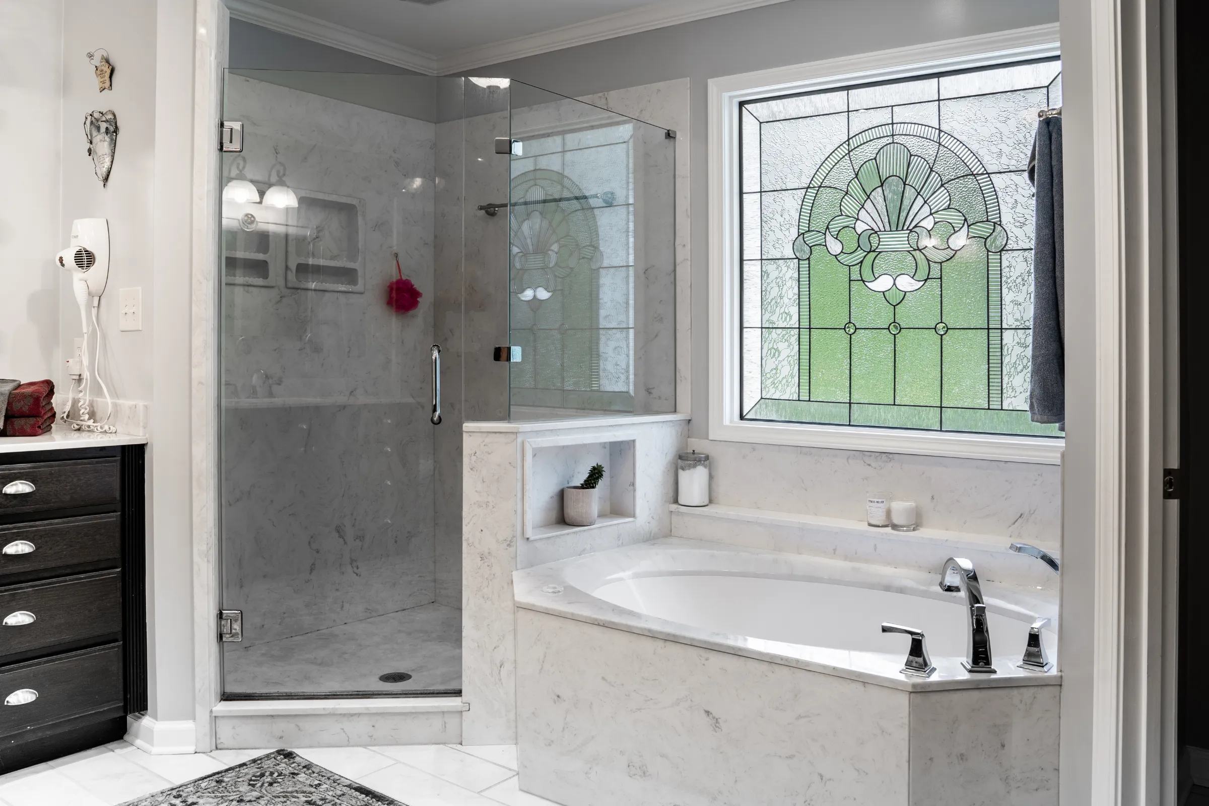 Bathroom remodeling in Los Angeles with marble tile, glass shower enclosure, soaking tub, natural light, and luxury spa-style finishes